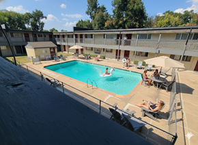 Tulsa apartment for rent - A swimming pool with people relaxing on the sun loungers.