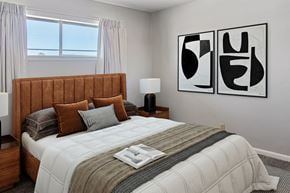 Tulsa apartment for rent - A bedroom with a large bed and two abstract art pieces on the wall.