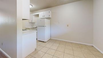 Tulsa apartment for rent - A kitchen with white cabinets and a white refrigerator.