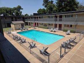 Tulsa apartment for rent - A pool surrounded by chairs and a fence.