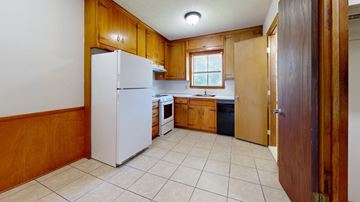 Tulsa apartment for rent - A kitchen with wooden cabinets and a white refrigerator.