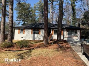 Marietta house for rent - a small white house in the woods with tall trees