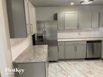 Marietta house for rent - a kitchen with white cabinets and stainless steel refrigerator