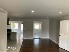 Marietta house for rent - an empty living room and kitchen with white walls and wood floors