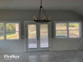 Marietta house for rent - an empty living room with windows and a chandelier