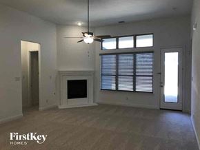 Grand Prairie house for rent - A spacious room with a fireplace and a ceiling fan.