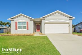 Cocoa house for rent - A two-story house with a red door and garage door is for sale.