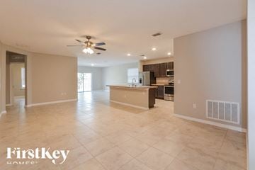 Cocoa house for rent - A spacious kitchen and living room with a tiled floor and a ceiling fan.