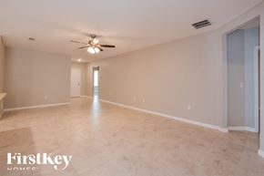 Cocoa house for rent - A spacious room with a ceiling fan and light fixture.