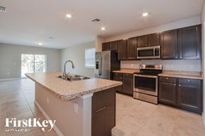 Cocoa house for rent - A kitchen with a granite countertop and stainless steel appliances.