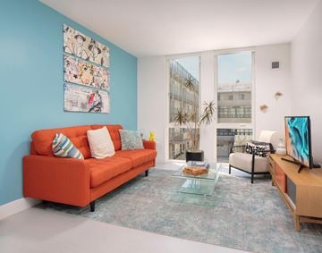 San Diego apartment for rent - a living room with a orange couch and a window