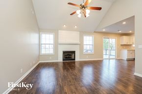 Clarksville house for rent - A spacious living room with a fireplace and hardwood floors.