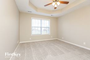 Clarksville house for rent - A spacious room with a ceiling fan and a window.