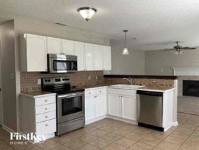 Charlotte house for rent - a kitchen with stainless steel appliances and white cabinets