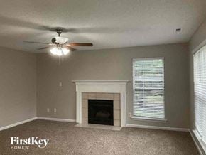 Charlotte house for rent - a living room with a fireplace and a ceiling fan