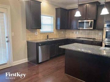 Lithia Springs house for rent - a kitchen with black cabinets and stainless steel appliances