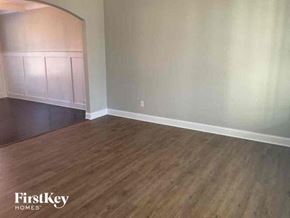 Lithia Springs house for rent - an empty living room with wood floors and white walls