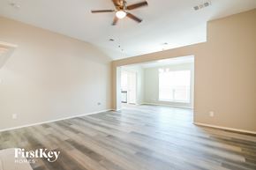 Forney house for rent - an empty living room with wood floors and a ceiling fan