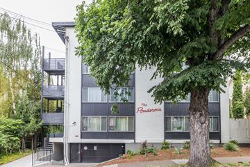 Oakland apartment for rent - A tree in front of a grey building with a red sign that says Pendarosa.
