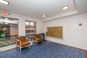 Oakland apartment for rent - A room with a blue carpet and a white wall with a bulletin board and two chairs.