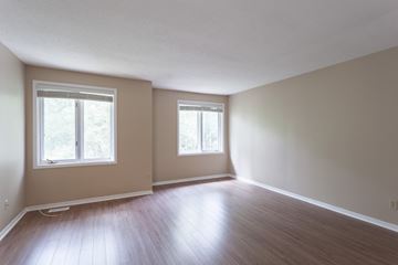 Ottawa apartment for rent - an empty living room with wood floors and two windows