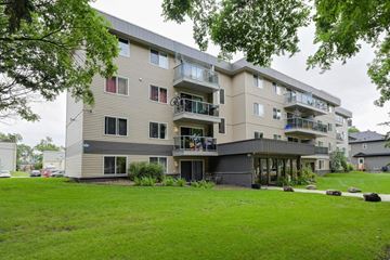 Edmonton apartment for rent - an apartment building with a green lawn in front of it