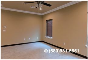 Durant apartment for rent - A room with a ceiling fan and a window with blinds.