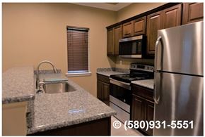 Durant apartment for rent - A kitchen with a stainless steel refrigerator, microwave, and oven.