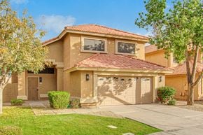 Gilbert house for rent - a beige house with a garage and trees