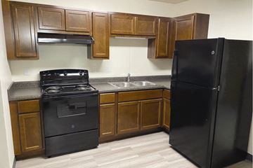 Kokomo apartment for rent - a kitchen with black appliances and wooden cabinets