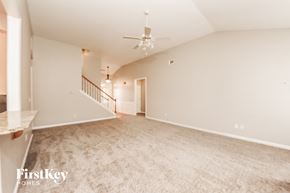 Cumming house for rent - A spacious, empty room with a staircase and a ceiling fan.