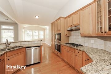 Cumming house for rent - A kitchen with wooden cabinets and granite countertops.