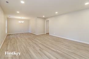 Lewisville house for rent - A spacious room with wooden flooring and a chandelier.