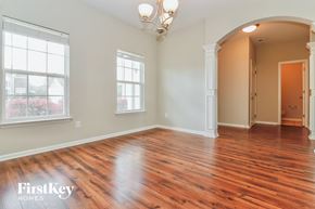 Moncks Corner house for rent - an empty living room with wood flooring and a door to a hallway