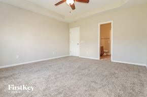 Moncks Corner house for rent - a spacious living room with carpeting and a ceiling fan