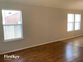 Waxahachie house for rent - an empty living room with wood floors and a window
