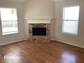 Waxahachie house for rent - a living room with a fireplace and a wooden floor