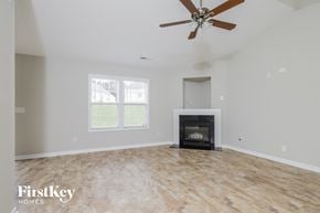 Winston Salem house for rent - a living room with a fireplace and a ceiling fan