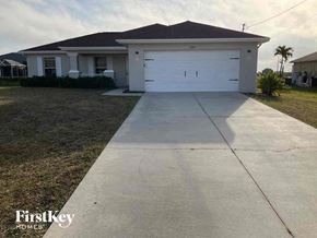 Cape Coral house for rent - a white house with a driveway and a white garage door