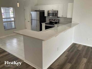 Cape Coral house for rent - a kitchen with a counter top and a refrigerator
