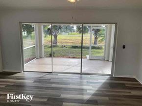 Cape Coral house for rent - a living room with a view of a yard and glass doors