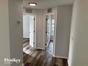 Cape Coral house for rent - a renovated living room and hallway with wood floors and white walls