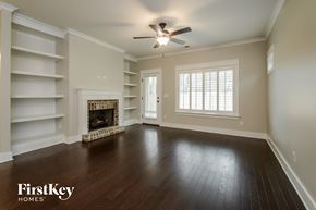Irondale house for rent - A spacious room with a fireplace and a ceiling fan.
