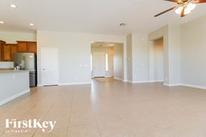 Goodyear house for rent - A spacious living room with a kitchen in the background and a ceiling fan.