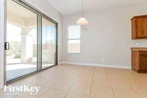 Goodyear house for rent - A room with a sliding glass door leading to a balcony, a ceiling light, and a wooden cabinet.