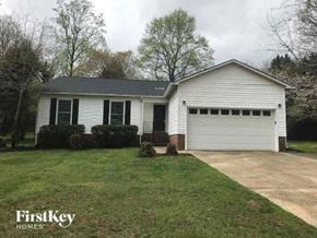 Gastonia house for rent - a white house with a driveway and a lawn