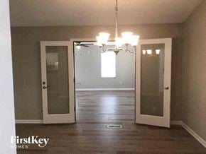 Gastonia house for rent - a empty living room with two doors and a chandelier