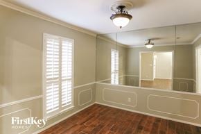 Houston house for rent - an empty dining room with a large mirror and wood floor