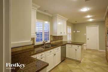 Houston house for rent - a white kitchen with granite counter tops and white cabinets