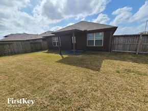 Katy house for rent - a backyard with a house and a yard with grass